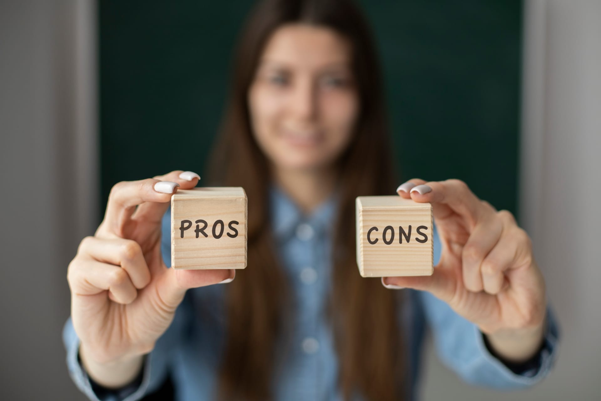 Frau hält Würfel mit den Aufschriften Pros und Cons