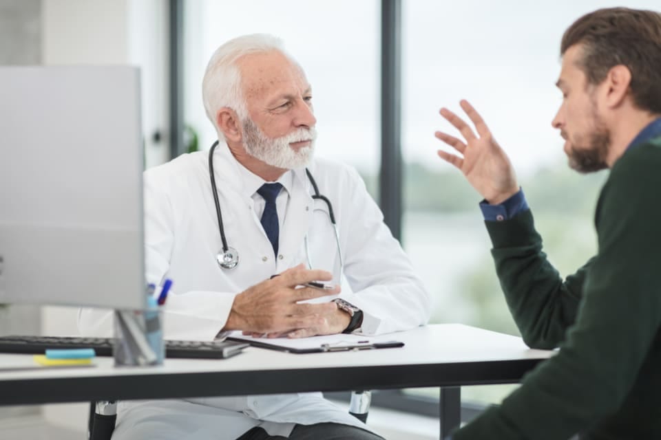 Arzt im Gespräch mit einem Patienten in der Praxis