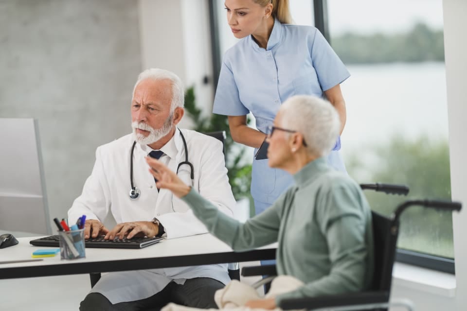 Arzt und Pflegekraft im Gespräch mit einer Patientin