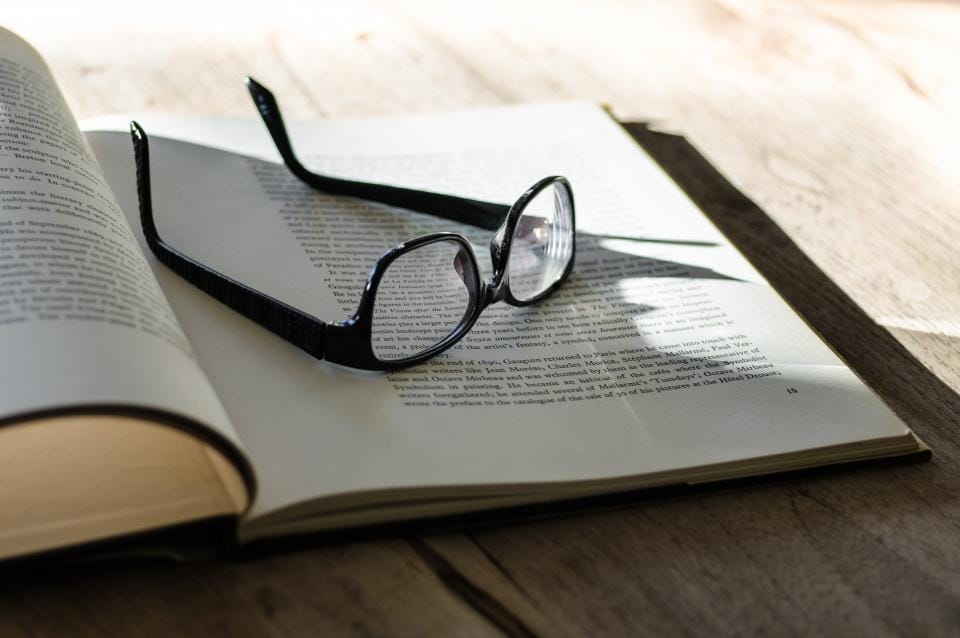 Brille auf einem aufgeschlagenen Buch