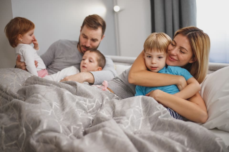 Eltern mit zwei Kindern entspannt zu Hause