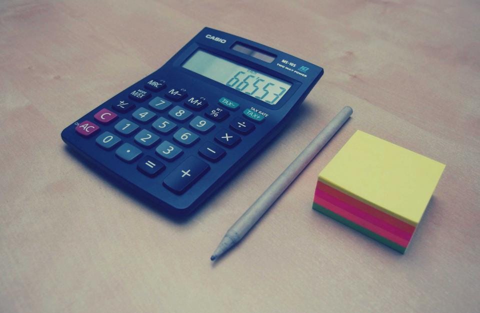 Taschenrechner mit Stift und Notizzetteln