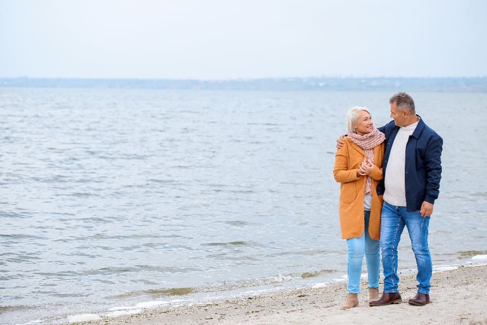 Älteres Paar spaziert am Strand