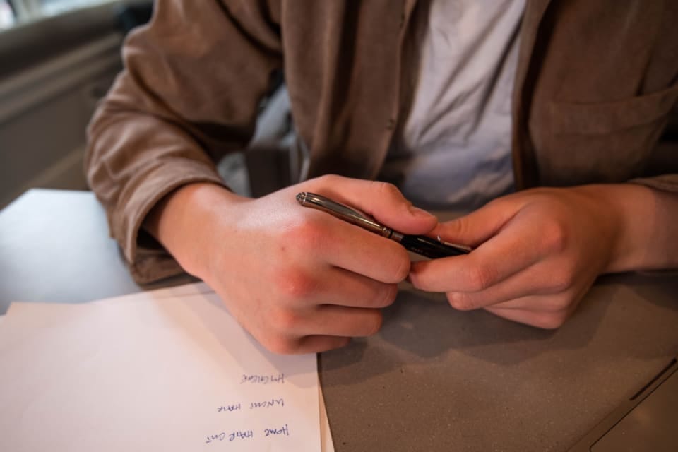 Hand mit Stift über einem Formular