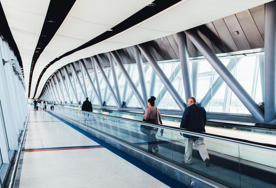 Reisende auf einem Laufband im Flughafen