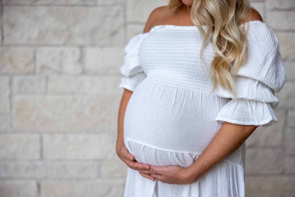 Schwangere Frau hält ihren Bauch